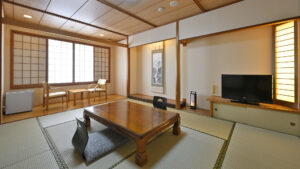 Chambre en tatami avec table basse, chaise de sol et chaises