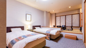 Lits jumeaux à côté d’un coin salon surélevé en tatami