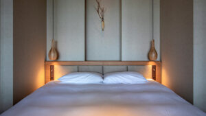 Doppelbett mit sanfter Beleuchtung und minimalistischem Kopfteil