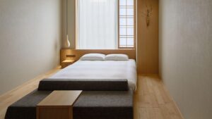 Niedriges Bett in minimalistischem Gästezimmer aus Holz