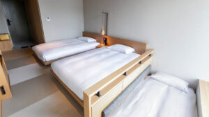 Drei niedrige Betten in einem minimalistischen Gästezimmer