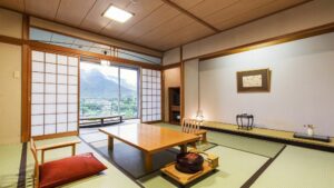 低いテーブルと窓の眺めがある畳の客室