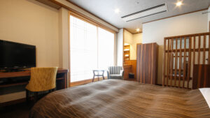 Bedroom with large bed, desk, and window seating