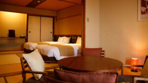 Round table and chairs beside beds in tatami room