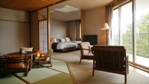 Tatami room with chairs, table, and beds beyond