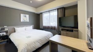 Double bed in guest room with TV and desk