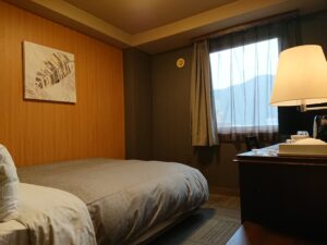 Twin beds beside a window and desk