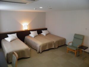 Drei Einzelbetten in einem einfachen Gästezimmer