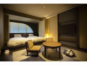 Zwei Betten neben einem niedrigen Tisch und einem Bodenstuhl