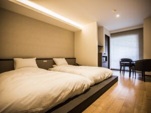 Zwei Betten in einem Gästezimmer mit Tisch und Stühlen