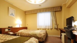 带书桌和电视的客房内的双床