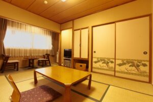 低いテーブルと窓際の座席がある畳の部屋