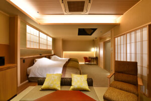 Camera di ryokan con letti singoli e area salotto in tatami