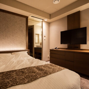 客室の壁掛けテレビに向いたベッド
