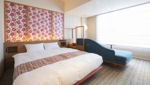 客室内の青いシェーズロング横のダブルベッド