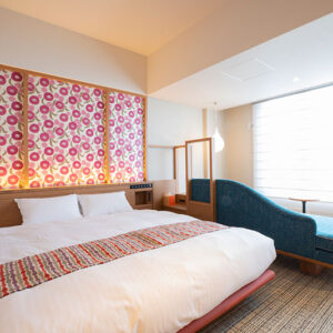 曲線ソファと窓のそばにあるダブルベッド