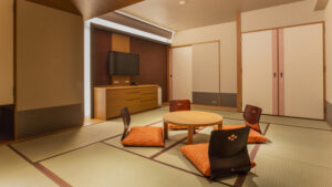 丸い低いテーブルと座椅子のある畳の客室