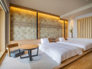 小さなテーブルと椅子のそばにある低いベッド2台