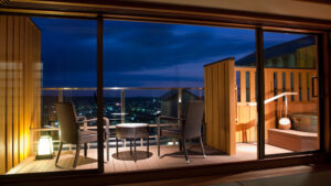 Private open-air bath and balcony seating at night