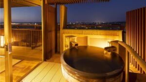 Private open-air bath on a balcony at night