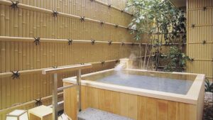 Private wooden open-air bath beside bamboo wall