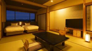 Tatami room with low table, chairs, and two beds