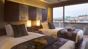 Two beds beside a large window in guest room