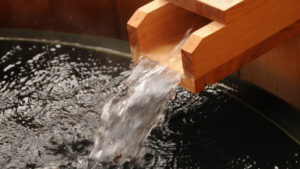 Water flowing from wooden spout into bath