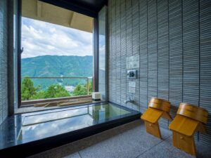 Bagno privato con vista sulle montagne e sgabelli in legno