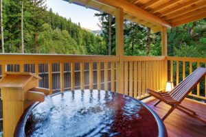 Bagno privato all'aperto su balcone in legno con vista sulla foresta