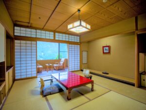 Camera in tatami con tavolo basso e sedie vicino alla finestra
