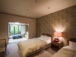 Letti singoli in una camera con area salotto in tatami