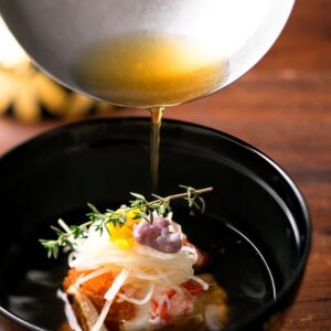 Angerichtetes Gericht, über das Brühe gegossen wird