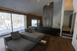 Sitzbereich mit Sofa neben großen Fenstern im Gästezimmer